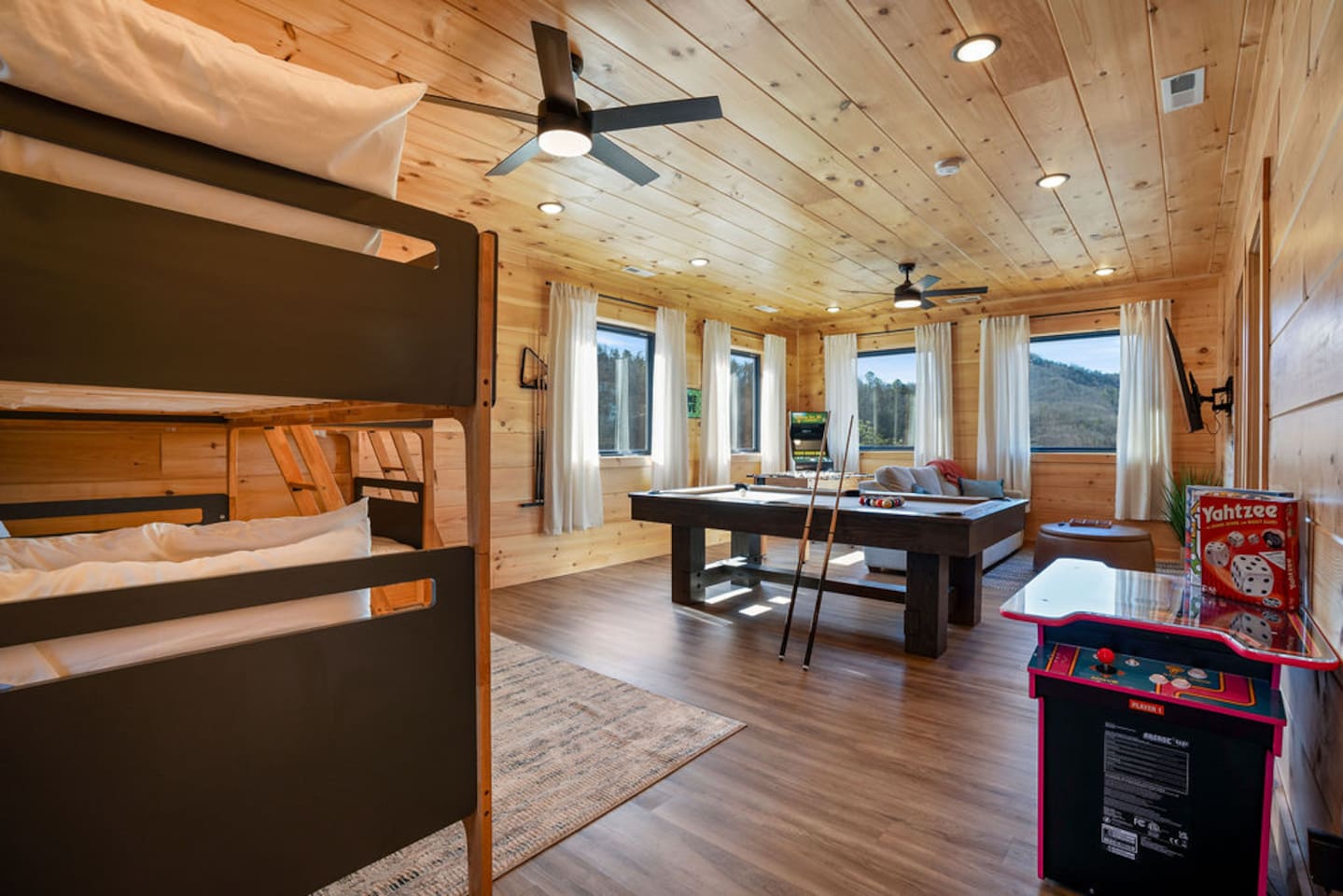 Bunk beds beside the game room with pool table and arcade cabinet