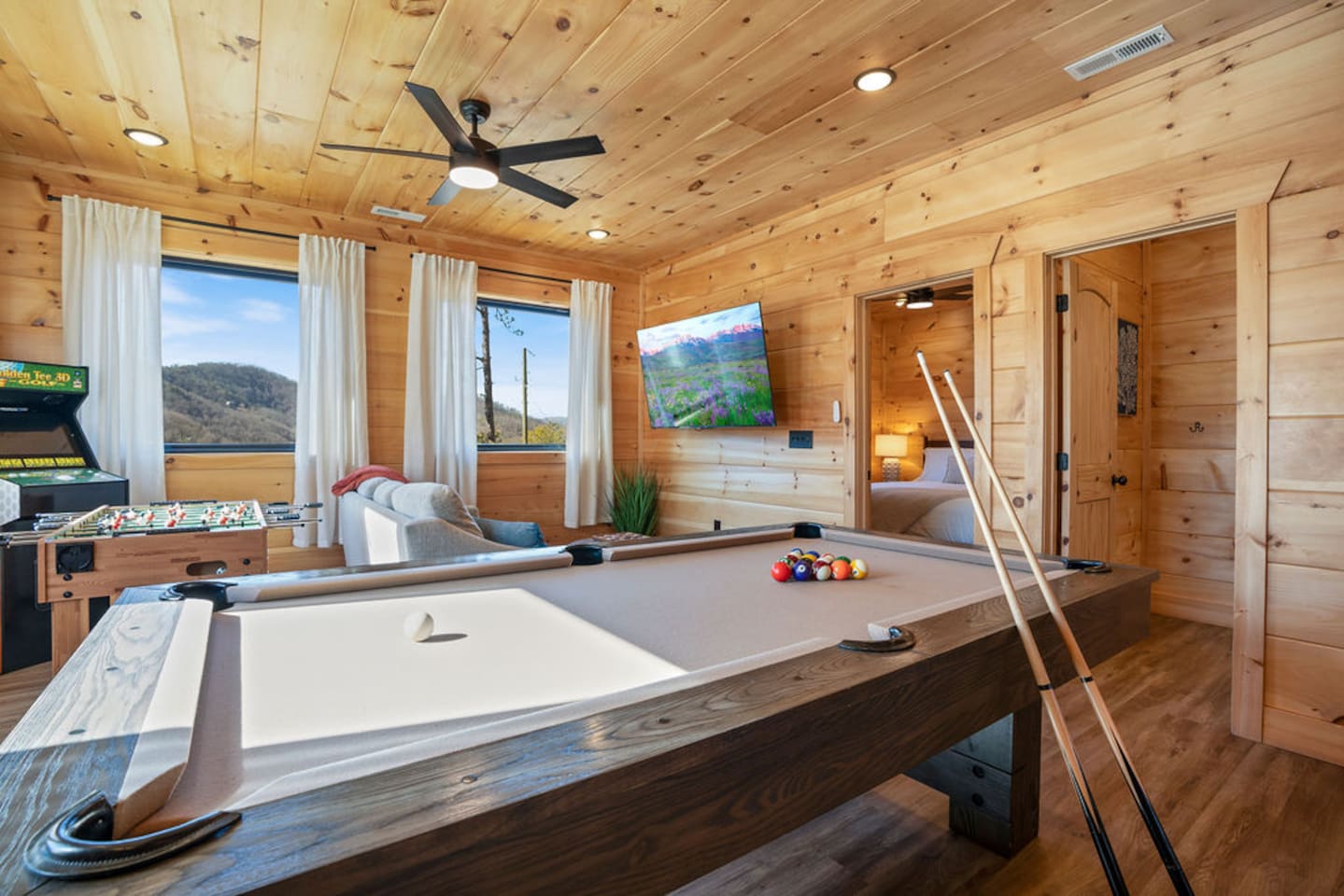 Game room with pool table, arcade cabinets, and mountain view windows