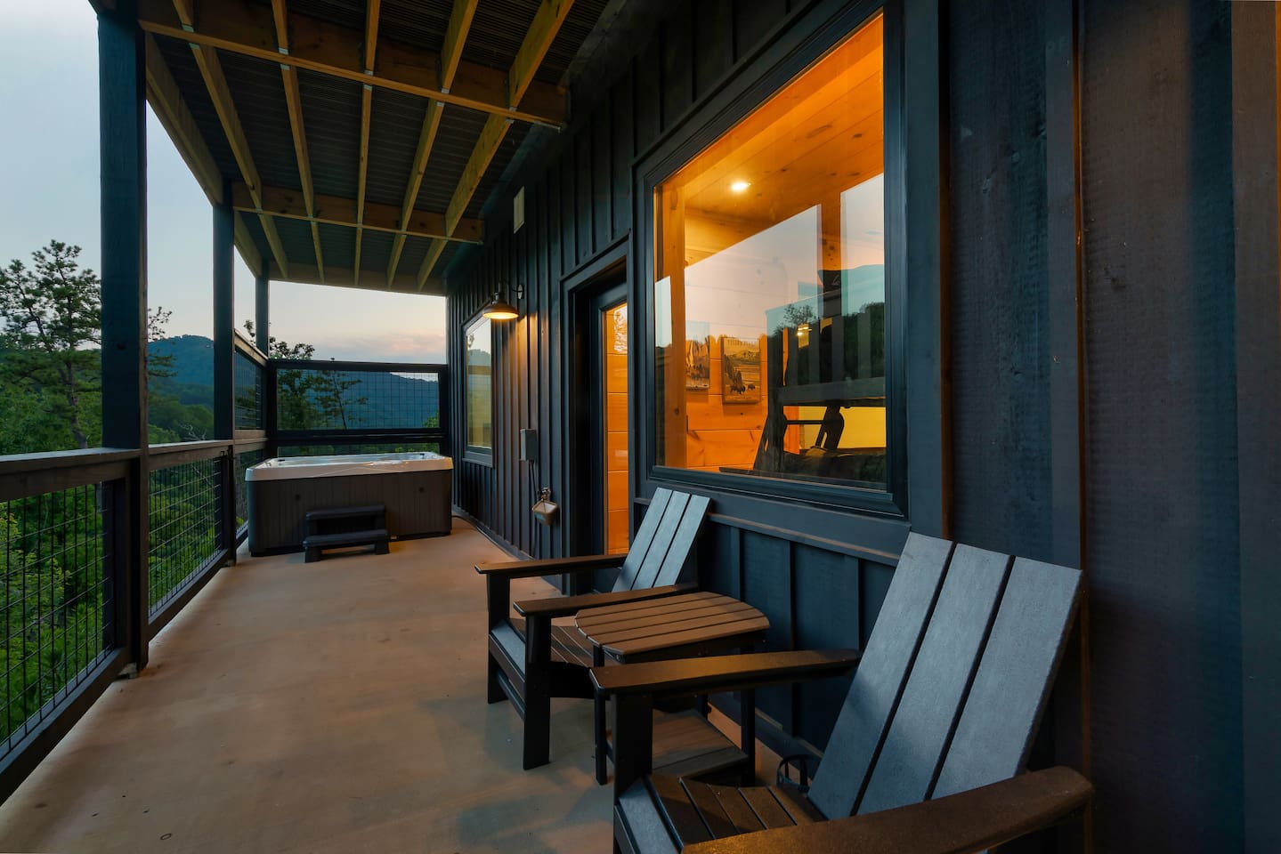 Outdoor hot tub on the covered cabin deck with forest views