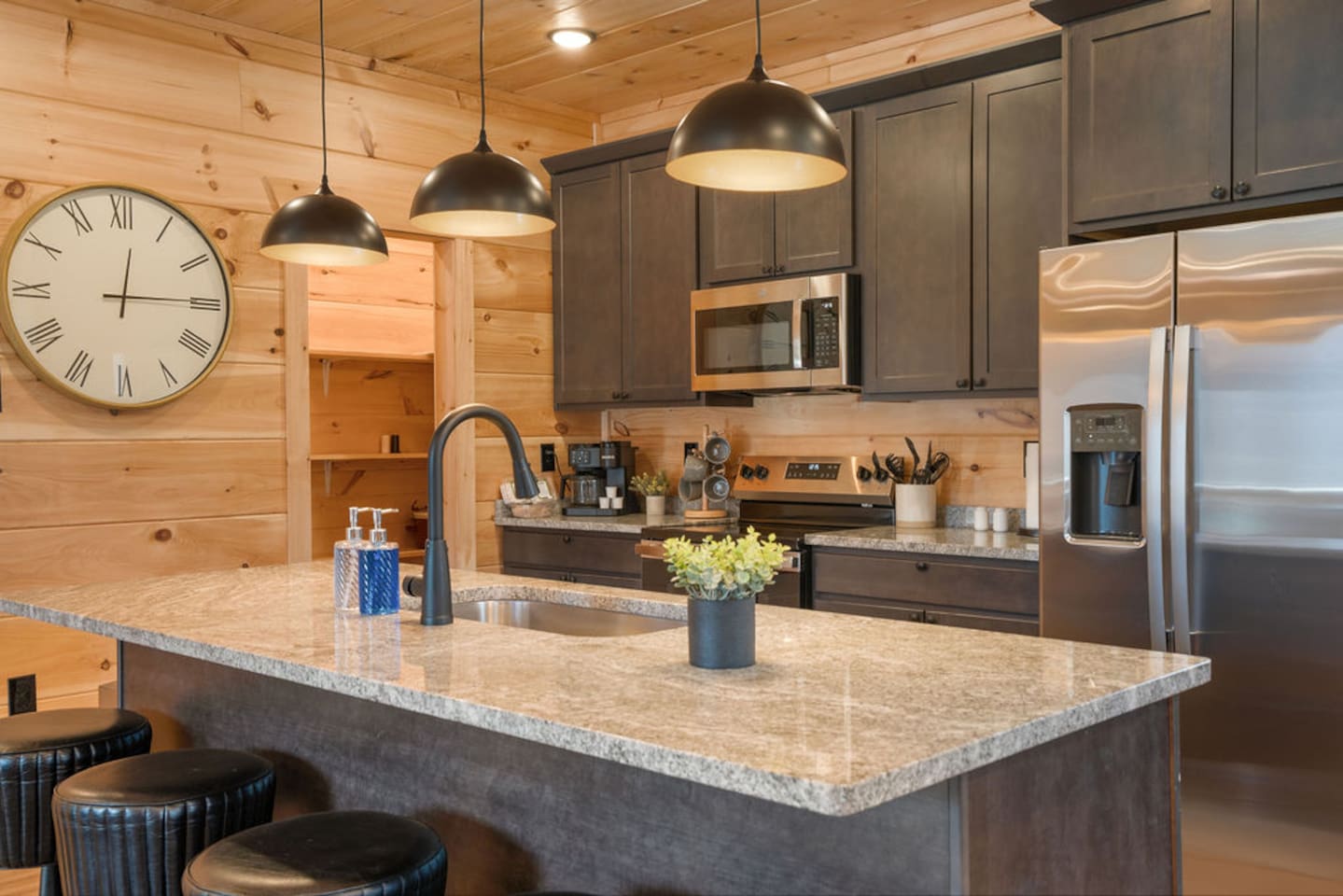 Fully equipped kitchen with granite island seating and pine cabin walls