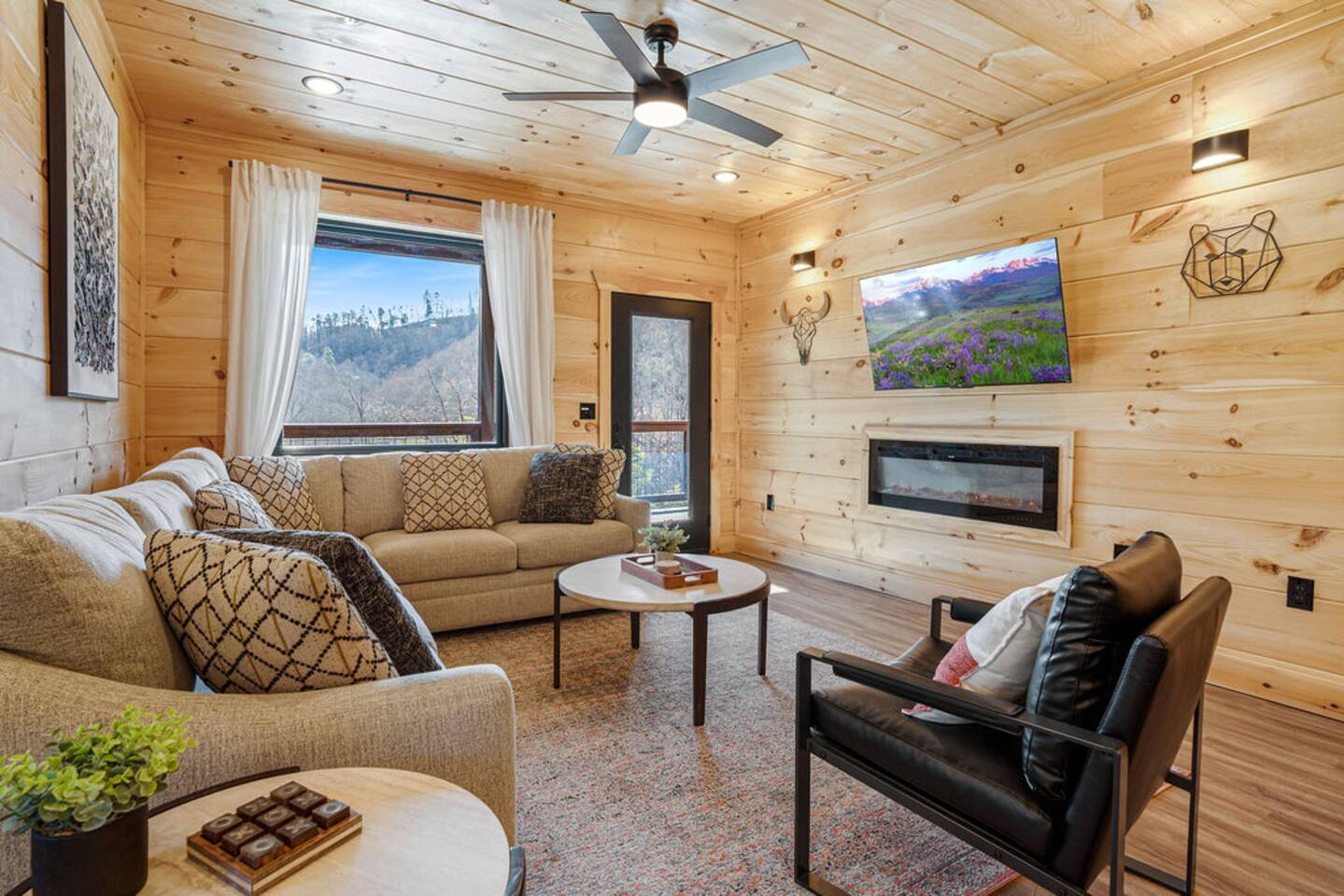Living room with sectional, fireplace, TV, and mountain view window
